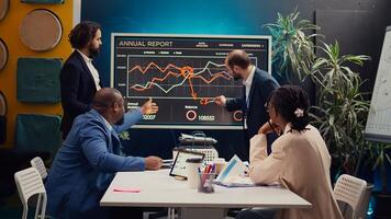 Marketing team attending a tensed meeting to review sales trends on interactive board, looking for ways to increase the organization profit and ensure global success. PR specialists. Camera B. photo