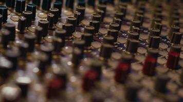 Pre amp knobs and switchers on mixing console panel board, audio stereo equipment used in music post production. Empty control room in professional studio, fader and sliders. Close up. photo