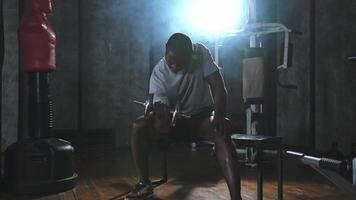 Fitness trainieren im Fitnessstudio. afrikanisch amerikanisch Mann Bodybuilder pflücken oben Hanteln im Fitnessstudio. trainieren Gewicht Ausbildung Bizeps Muskeln mit Hantel im Fitness Verein. Mann tun Sport Übung. gesund Lebensstil video