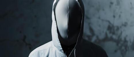 Person Wearing White Hoodie and Mask Standing in Front of a Wall photo