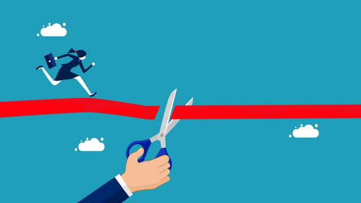 businessman cutting a red ribbon to cross the finish line