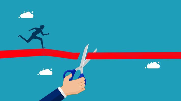 businessman cutting red ribbon to cross the finish line