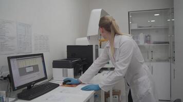 Scientist woman works at her workplace in laboratory, uses personal computer. Development, analyzes and genetics. Pharmaceutical Research Center. Microbiologist checks data on computer in the lab. video