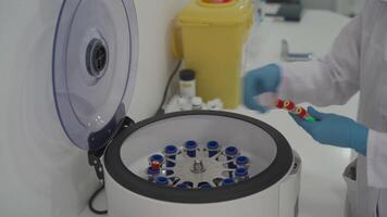 Platelet-Rich plasma preparation. Tube with blood in hands. Centrifuge. Medical worker in gloves inserts the tube in centrifuge. modern robotical machine for centrifuge blood and urine testing video