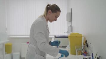 Woman working with pipette for test blood in laboratory in hospital. Clinical lab assistant collects biomaterial with special pipette. Scientist with dispenser doing hematological analysis. video