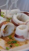 Frozen squid rings on a simple background. Squid rings video