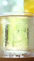 Cold juice Macro refreshing soda tonic fizzy sparkling water, lime in glass, ice cubes. Slice of lemon, mineral bubbles. Healthy, dietary nutrition. Cold lemonade mojito cocktail twinkling carbonated video