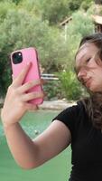 A woman holds a mobile phone in her hands, takes a selfie, communicates on the Internet, social networks, blogs. video