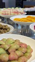Fruit buffet. Various tropical fruits on a buffet table on white plates are cut and displayed for visitors video
