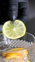 Sliced lemon cucumbers and mint leaves on a wooden cutting board next to a glass carafe with sparkling water. Male hand throwing slices of lemon in a glass of soda video