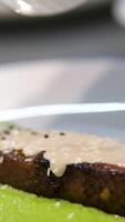 Cooking salmon steak grilling fillet salmon with asparagus, tomato, lemon. A chef's hand is squeezing a fresh lemon over a peace of red sea fish. Cooking process. Slow motion. close up video