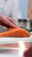 Cooking salmon steak grilling fillet salmon with asparagus, tomato, lemon. A chef's hand is squeezing a fresh lemon over a peace of red sea fish. Cooking process. Slow motion. close up video