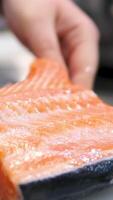 Cooking salmon steak grilling fillet salmon with asparagus, tomato, lemon. A chef's hand is squeezing a fresh lemon over a peace of red sea fish. Cooking process. Slow motion. close up video