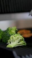 Grilled broccoli Chef cooking grilled broccoli pieces on the professional restaurant kitchen table. Vegan food. video