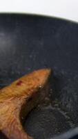 Fry salmon in a frying pan Salmon steak is placed on a frying pan and fried. Slow motion of cooking diet fish in the kitchen at home. High quality 4k footage video