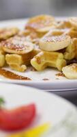 Poached egg Benedict on a sandwich plate Belgian waffles with caramel and sugar sprinkles. Decadence, Caramelized, Dusting concept video