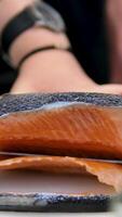 Sushi Chef Slices fresh Salmon on the sushi bar. Chef cutting salmon fillet at professional kitchen. Closeup chef hands slicing fresh fish slice in slow motion. Professional man cutting red fish video