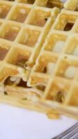 Square waffles Gold Belgian or Viennese waffles close-up. Waffle texture or background. Homemade baking for breakfast. video