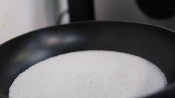 sugar in a frying pan home cook mixes ingredients to make homemade caramel. Fry the cinnamon, sugar and butter in a frying pan. video