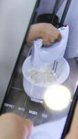 filming a mixer whipping cream on a mobile phone. baker's blog. blogger whips with a mixer video