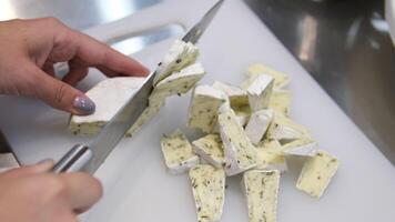 cut brie cheese with herbs Close-up of brie cheese in pieces on a cutting board. Cheese preparation. Restaurant food. man's hand picking slice of camembert cheese or brie. Wine appetizer set video