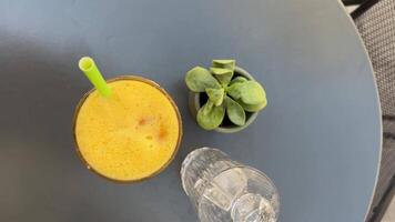 Freshly squeezed orange juice in a glass on a grey background video