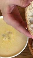 Champignon mushrooms in creamy sauce and champignon cream soup. Lunch at restaurant. Two dishes, basket of bread, fork and knife on table. Wooden table. Side view. Soft focus soft bread cream soup video