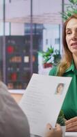 Vertical During a structured job interview, applicant presents her cv to a business recruiter, elaborating on their career history and aspirations. Career development within the enterprise. Camera A. video