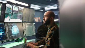 Army specialist employing AI tech to improve military warfare systems and threat monitoring. IT admin uses neural networks to enhance combat operational capabilities, camera B video
