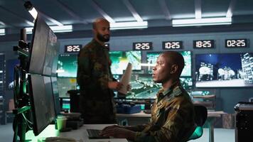 Soldier in military HQ base doing brainstorming with coworker, gathering information on enemy troops. Teamworking officers using tracking software to do assessment of enemy vulnerabilities, camera B video