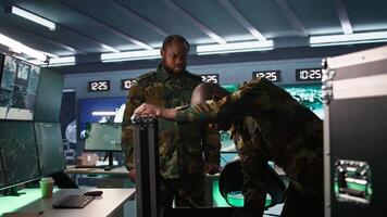 Military officers working together to check guns in command post, ensuring bullets and supplies are working properly. Team of soldiers holding pistol and rifles, managing combat load gear, camera B video