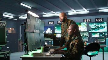Team of army telecommunications operators using radio and satellite gear, cooperating to provide combat support. Teamworking military dispatchers colleagues managing communications networks, camera B video