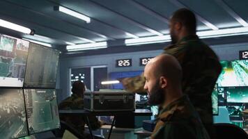 Military officer using tracking software to be able to offer info to front lines commander. Army expert doing reconnaissance to gain intel helping troops, coordinating mission activities, camera B video