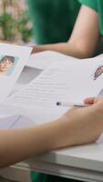 Vertical Recruiter rejecting an unqualified job candidate during the selection process, writes the refusal on their resume. HR team not pleased with unsuitable unprepared applicants, CV evaluation. Camera A. video