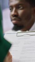 Vertical HR recruiters and applicant reading the employment agreement terms before signing the contract and becoming a new employee. People discussing about the multinational company policy. Camera A. video