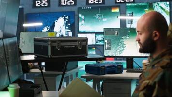 Military officer using tracking software to be able to offer info to front lines commander. Army expert doing reconnaissance to gain intel helping troops, coordinating mission activities, camera A video