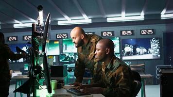Army telecommunications operators using radio and satellite gear, inputting data on systems. Military dispatchers managing communications networks, typing on keyboard, camera B video