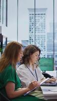 Vertical Team of employers questioning a job applicant during an interview within the HR department office, headhunting. Businesswomen reviewing CV and discussing job prospects. Camera B. video