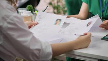 Recruiter rejecting an unqualified job candidate during the selection process, writes the refusal on their resume. HR team not pleased with unsuitable unprepared applicants, CV evaluation. Camera A. video