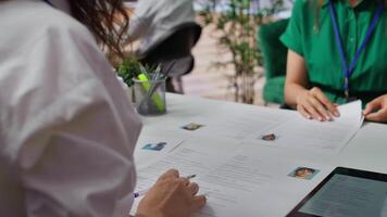 HR staff going through the selection process phase of the recruitment activity, choosing the best applicant based on their qualifications in the resume. Recruiters seeking talent. Camera B. video