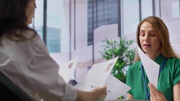 Headhunters team going through selection process by reviewing CVs after interview with all the job candidates, looking to hire personnel. HR recruiters evaluating resumes for job offer. Camera A. video