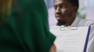 HR recruiters and applicant reading the employment agreement terms before signing the contract and becoming a new employee. People discussing about the multinational company policy. Camera A. video
