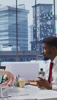 Vertical Male job candidate filling in his application form in high end office, attending an interview for a job offer within a corporation. Businessman writing his information on document. Camera B. video