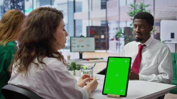 Job applicant and employer discussing in an interview with isolated mockup display on a device, high end corporate office. Businessman and HR recruiter share career development ideas. Camera B. video