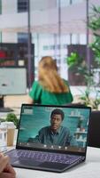 Vertical HR recruiter hosting an online interview with job applicant via internet teleconference call, evaluating candidate CV and discussing about career plans. Recruiting on remote videocall. Camera B. video