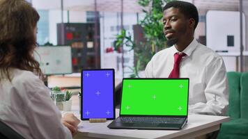 HR staff discussing with applicant next to mockup chroma key screens at the job interview, working on talent acquisition. Job seeker going through recruitment process, job search. Camera A. video