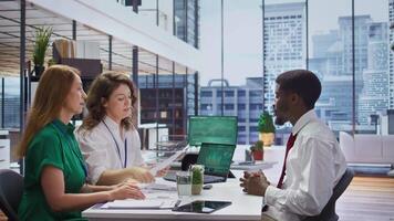 Applicant gives his CV to human resources staff to begin the job interview, reviewing the qualifications and work experience from the application form. Discussing job roles available. Camera B. video