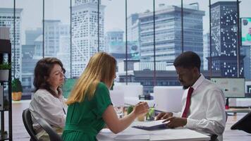 New employee signing his work contract after successful job interview with the HR staff, businesswomen shaking hands and welcoming man to the team. Job applicant securing a position. Camera B. video