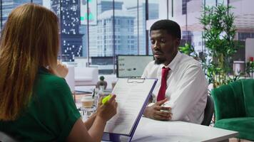 HR recruiters and applicant reading the employment agreement terms before signing the contract and becoming a new employee. People discussing about the multinational company policy. Camera B. video
