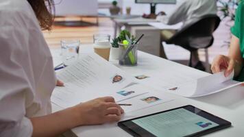 Team of recruiters selecting candidates based on their resumes, looking for the right person to fill in job vacancy. HR staff evaluating the qualifications of applicants after interview. Camera B. video